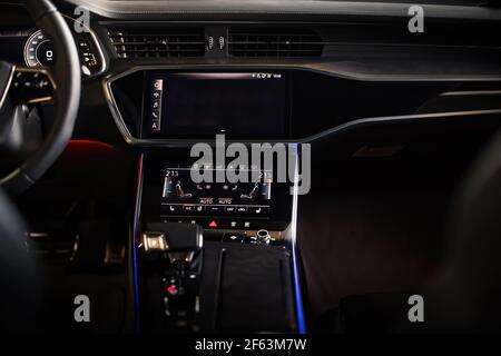 Innenraum eines ultramodernen neuen Luxuswagens. Ledersessel und Holzverkleidung, Touch-Panels mit Vibrationsrückmeldung und Klimaregelung. Multifunktions-, Automatikgetriebe Stockfoto