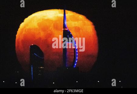 Portsmouth, Hampshire. 29th. März 2021. Wetter in Großbritannien. Der Super Worm Moon steigt an einem klaren Abend an der Südküste hinter dem Spinnaker Tower in Portsmouth auf. Der Supermond scheint den 560 Meter hohen Turm in den Schatten zu stellen, als er sich vom Horizont erhebt. Credit Stuart Martin/Alamy Live News Stockfoto