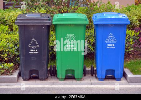 3 farbige Mülltonnen für Abfall und Recycling in China. Anders als der Rest der Welt verwenden sie Blau als Recycling, nicht Grün. Stockfoto