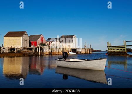 Ruderboot vor Blue Rocks in Nova Scotia, Kanada. Schuppen für die Lagerung von Angelausrüstung reflektieren im Wasser. Stockfoto