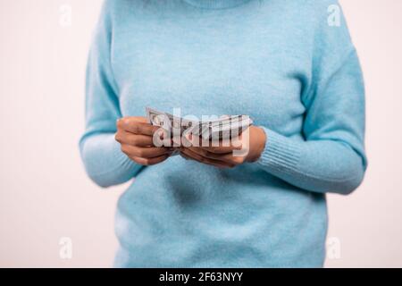 Hände der Frau, die USD-Währung zählt. Lady Counts Money - Dollar-Banknoten an der weißen Wand. Symbol für Erfolg, Gewinn, Sieg. Stockfoto