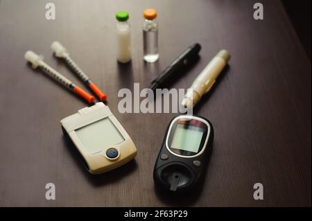 Medizin, Diabetes und Health Care Concept - Nahaufnahme der Blutzuckertest Streifen, glucometer, Diabetes Insulin pen und anderen Tools auf Tisch. Stockfoto