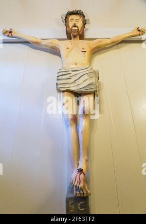 Jesus am Kreuz Holzskulptur an der Wand der Treppe Zum Kellerzimmer in einem alten, ca. 1790 Kanadischen Gebäude Haus im Cottage-Stil Stockfoto