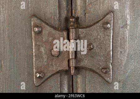 Nahaufnahme von handgefertigten Schmetterling Stil Metall Türscharnier auf antik Holzschrank Stockfoto