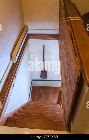 Geölte gelbe Kiefernholzfalle Tür und Treppe, die von Stock oben zum Wohnzimmer in einem alten 1825 Canadiana Landhaus-Stil Feldsteinhaus Stockfoto