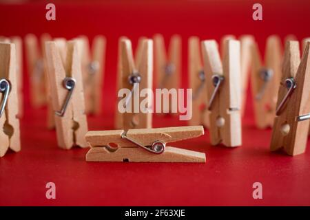 Darstellung von Menschen mit Wäscheklammern. Konzept der Krankheit oder Tod und letzte Auf Wiedersehen. Selektiver Fokus auf rotem Hintergrund. Stockfoto