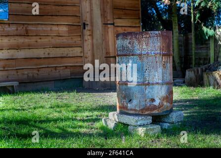 Rostiger alter, verkohlter Stahlfirepit im Garten. Stockfoto