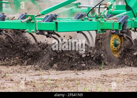 Nahaufnahme des Ackerbauers Arbeitsboden auf dem Feld. Konzept der Pflanzsaison, Bodenbearbeitung und Wartung der Ausrüstung Stockfoto