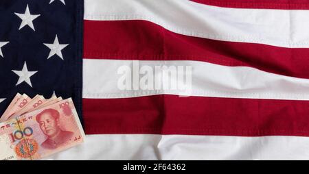 Winkende Tuch US-Flagge mit chinesischen Yuan Währung in niedriger Linke Ecke für Trade war Konzept Stockfoto