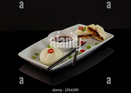 Bao Buns mit Dipping Sauce und Essstäbchen Stockfoto