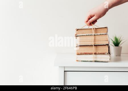 Hand hält einen Stapel von alten Büchern in der Bibliothek, Konzept des Lernens, Studium und Bildung, Konzept der Wissenschaft, Weisheit und Wissen. Hochwertige Pho Stockfoto