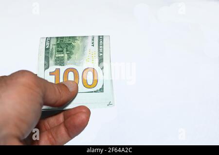 Nahaufnahme der Hand eines jungen Mannes, der 100-Dollar-Banknoten gibt Isoliert auf weißem Hintergrund Stockfoto