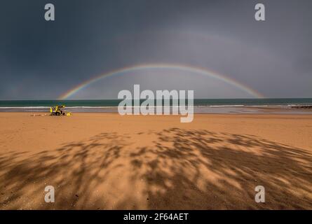 Ein doppelter Regenbogen bildet sich nach einem Sturm über dem Meer Stockfoto