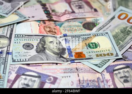 Saudi-Arabien Währung mit US-Dollar-Banknoten. Verschwommenes Geld. Saudi Geld und amerikanische Dollar Wechselkurs, 100 Dollar , verschiedene saudische Riyals Stockfoto