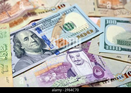 Saudi-Arabien Währung mit US-Dollar-Banknoten. Verschwommenes Geld. Saudi Geld und amerikanische Dollar Wechselkurs, 100 Dollar , verschiedene saudische Riyals Stockfoto