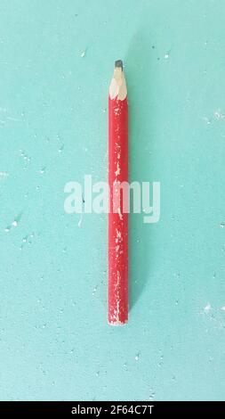 Roter Baustift auf schmutzigem grünem Trockenbau. Stockfoto