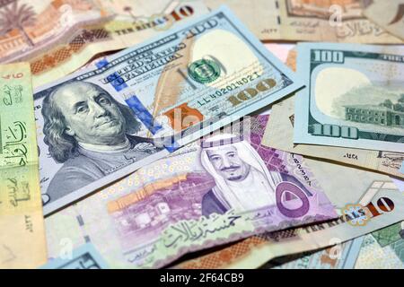 Saudi-Arabien Währung mit US-Dollar-Banknoten. Verschwommenes Geld. Saudi Geld und amerikanische Dollar Wechselkurs, 100 Dollar , verschiedene saudische Riyals Stockfoto