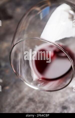 Rotwein im Glas auf dem rustikalen Hintergrund. Selektiver Fokus. Geringe Schärfentiefe. Stockfoto