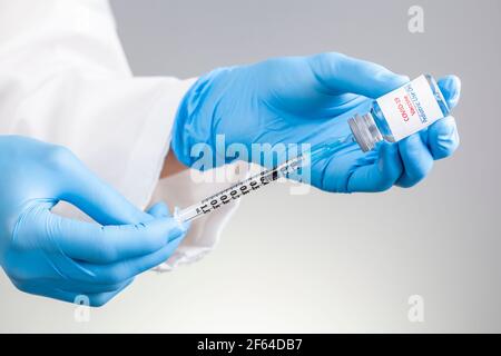 Konzeptbild mit COVID 19-Impfstoff, der nur für die pädiatrische Verwendung in einem Glasfläschchen mit einer gefüllten Nadel und Spritze vor der Verabreichung des Schusses entwickelt wurde. Stockfoto
