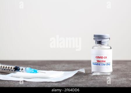 Konzeptbild mit COVID 19-Impfstoff für Kinder Nur in einem Glasfläschchen mit einer Nadel und Spritze Mit dem Impfstoff vor dem sh gefüllt Stockfoto