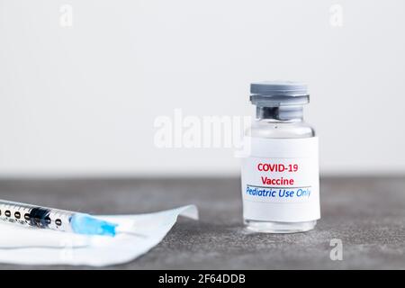 Konzeptbild mit COVID 19-Impfstoff für Kinder Nur in einem Glasfläschchen mit einer Nadel und Spritze Mit dem Impfstoff vor dem sh gefüllt Stockfoto