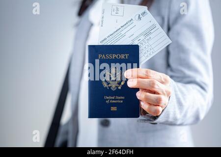 Clarksburg, MD, USA 03-29-2021: Eine kaukasische Geschäftsfrau zeigt ihre Reisedokumente am Flughafen einschließlich US-Pass, Bordkarte und COVID va Stockfoto