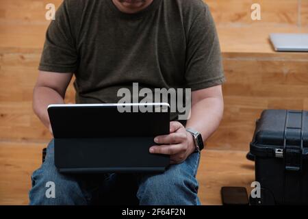 Junger Mann mit Videoanruf über Laptop. Junge Freelance mit digitalen Tablet und überprüfen ihre Bestellung Online-Shop. Home Office-Konzept. Stockfoto