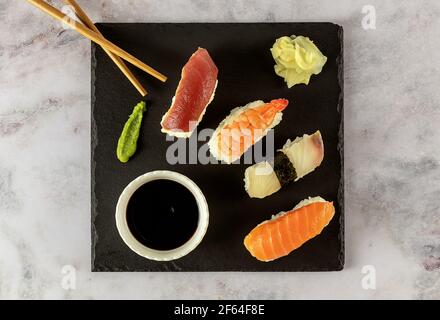 Japanisches Sushi-Essen. Nigiri mit Thunfisch, Lachs, Garnelen serviert mit Sojasauce, Ingwer und Wasabi. Stockfoto