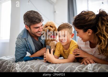 Glückliche junge freundliche Familie verbringen Spaß Zeiten zusammen und kuscheln Mit ihrem Haustier zu Hause Stockfoto