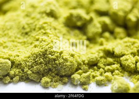 Grünes Pulver japanischer Matcha Tee Nahaufnahme. Das Pulver enthält eine Beimischung von weißen Granulaten Kokosmilch. Matcha Latte in trockener Form. Hintergrund, t Stockfoto