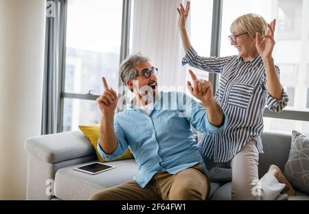 Aufgeregt reifes Paar mit Spaß zu Hause. Frau und Mann verbringen Wochenende zusammen, lustige Aktivität Stockfoto
