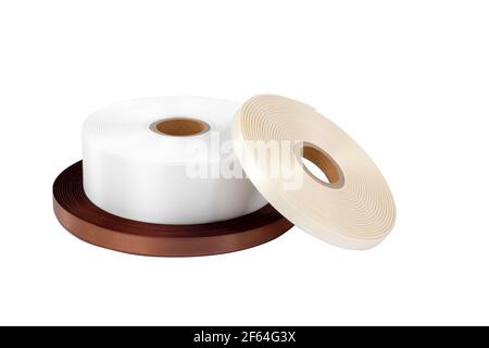 Drei Rollen Satinband für Etiketten oder Nähen in weiß, dunkelbraun und beige, isoliert ohne Schatten auf weißem Hintergrund Stockfoto