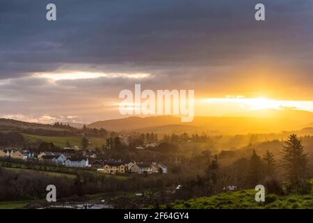 Ardara, County Donegal, Irland. 30th. März 2021. Die Sonne geht über dem ländlichen Dorf auf. Arbeitnehmer werden für den Umzug in ländliche Städte in kühnen neuen Plan zur Dezentralisierung Irlands bezahlt werden. Während eine große Mehrheit der Arbeitnehmer aufgrund von Covid-19 bereits von zu Hause aus arbeitet, wird der gestern von der Regierung vorgestellte Plan „Unsere ländliche Zukunft“ auch eine große „Dezentralisierung“ von mehr als 68.000 Beschäftigten im öffentlichen Sektor (20 %) aus den Hauptniederlassungen bis Ende des Jahres verzeichnen. Kredit: Richard Wayman/Alamy Live Nachrichten Stockfoto