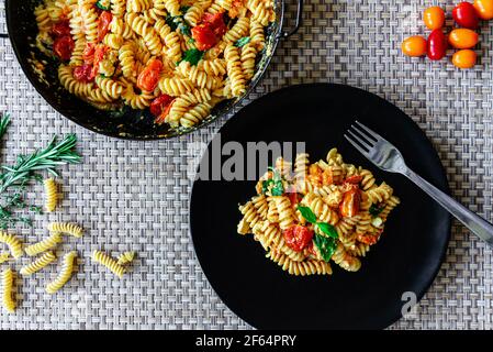 Gebackener Feta-Käse mit Pasta, Tomaten und frischem Basilikum Stockfoto