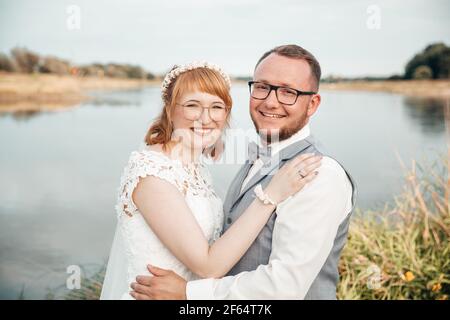 Glückliches Brautpaar neben einem Fluss Stockfoto