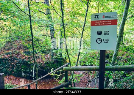 Signal mit COVID 19 Vorsorgemaßnahmen an einem Naturplatz. Quelle des Flusses Urederra. Stockfoto