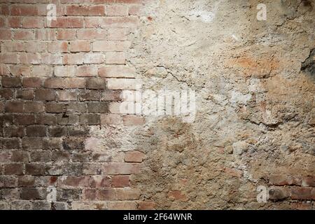 Alte Ziegel und Zementwand mit schwarz verbrannten Teil Stockfoto