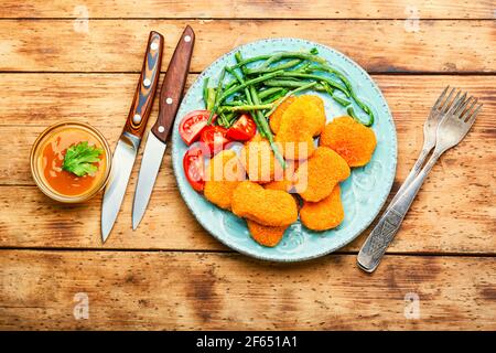 Köstliche Chicken Nuggets mit Kuhpfeiben und Tomaten Stockfoto