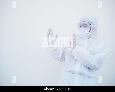 Asiatischer männlicher Arzt oder Wissenschaftler in PPE-Suite Uniform zeigt Stoppschild. Coronavirus oder COVID-19 Konzept isoliert weißen Hintergrund Stockfoto