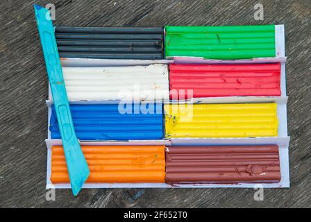 Set von bunten Plastilin-Sticks isoliert auf Holz Hintergrund. Regenbogen Modellierung Tonstück für Kinder spielen und Kreativität Stockfoto