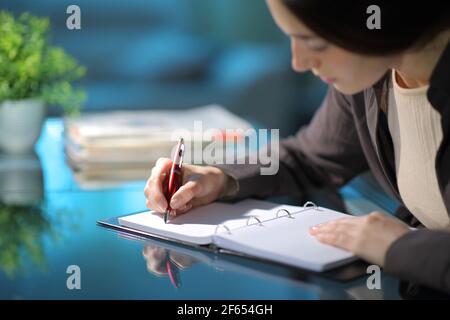 Nahaufnahme einer Frau, die Notizen auf Notizbuch in Die Nacht zu Hause Stockfoto