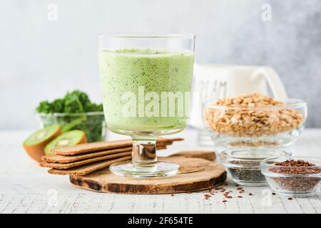 Entgiften Sie grünen Smoothie mit Grünkohl, Spinat und Kiwi auf hellgrauem Schiefer, Stein oder Beton. Draufsicht mit Kopierbereich. Stockfoto