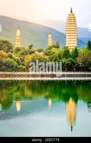 Schöne malerische vertikale Ansicht von Dali drei Pagoden von Chongsheng Tempel mit Wasserspiegelung und dramatischem Licht in Dali Yunnan China Stockfoto