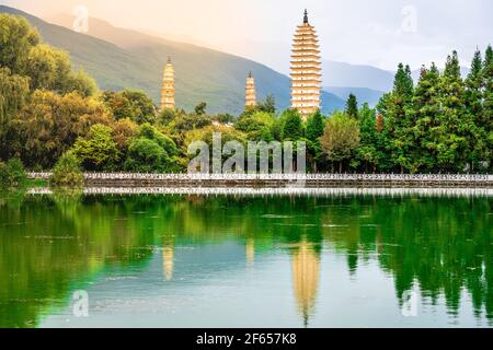 Schöne malerische Aussicht auf Dali drei Pagoden des Chongsheng Tempels Mit Wasserspiegelung und dramatischem Licht in Dali Yunnan China Stockfoto