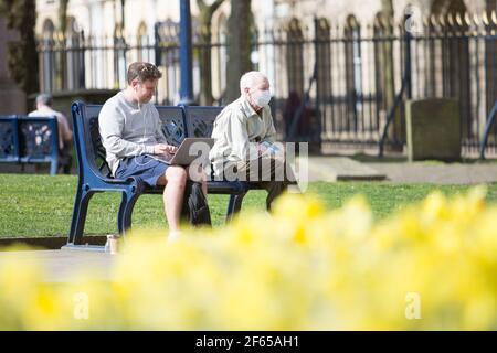 Birmingham, Großbritannien. März 2021, 30th. Zwei Männer genießen die Sonne auf dem Gelände der Kathedrale im Stadtzentrum von Birmingham. Kredit: Peter Lopeman/Alamy Live Nachrichten Stockfoto