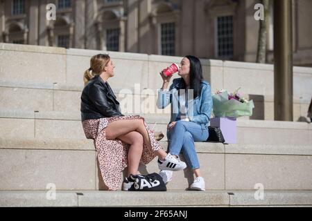 Birmingham, Großbritannien. März 2021, 30th. Büroangestellte entspannen sich in der Sonne auf dem neu entwickelten Chamberlain Square im Stadtzentrum von Birmingham. Kredit: Peter Lopeman/Alamy Live Nachrichten Stockfoto