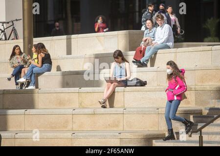 Birmingham, Großbritannien. März 2021, 30th. Büroangestellte entspannen sich in der Sonne auf dem neu entwickelten Chamberlain Square im Stadtzentrum von Birmingham. Kredit: Peter Lopeman/Alamy Live Nachrichten Stockfoto