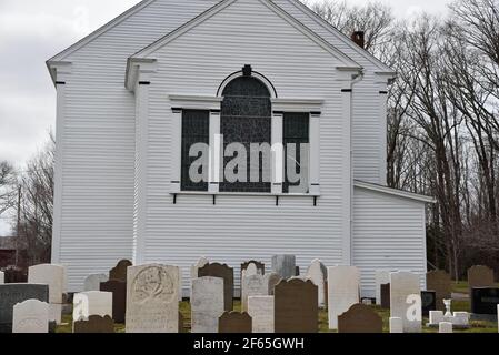 Schöne alte weiße Klapptafel St. John's Anglican Church, gegründet 1760, umgeben von alten Grabsteinen in Port Williams, Nova Scotia, Kanada Stockfoto