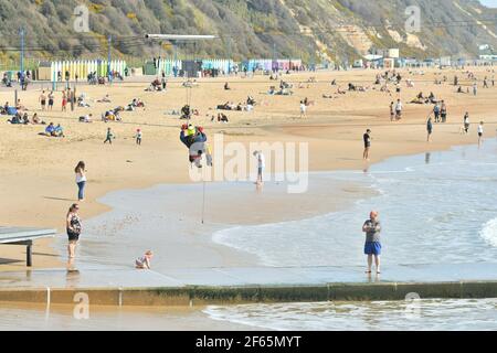 Bournemouth, Dorset, Großbritannien, 30.. März 2021, Wetter. Eine Hitzewelle im Frühjahr, Bei Der Ein Wartungsarbeiter an einem Kabel des Seilzugs hängt. Stockfoto