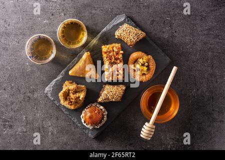 Auswahl an Ramadan Dessert Baklava und Datteln auf schwarzem Hintergrund Stockfoto